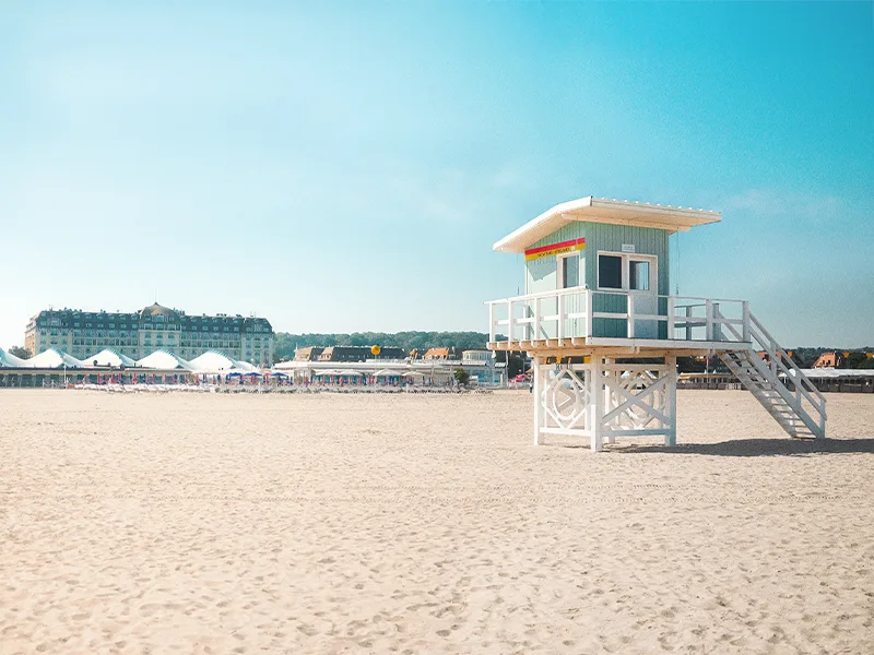 Une plage de la Côte Fleurie, son poste de secours et ses parasols