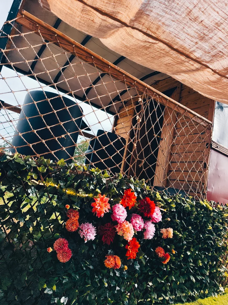 Le Luxury Circus — La voile d'ombrage et le massif de dahlias, le long de la roulotte