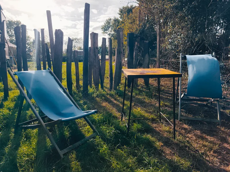 Le Luxury Circus — Deux transats et une table sur la pelouse privative, au soleil couchant
